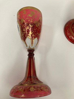 Lot 30 - A 19TH CENTURY BOHEMIAN GILDED AND PAINTED RUBY GLASS EWER AND GOBLET