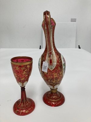 Lot 30 - A 19TH CENTURY BOHEMIAN GILDED AND PAINTED RUBY GLASS EWER AND GOBLET