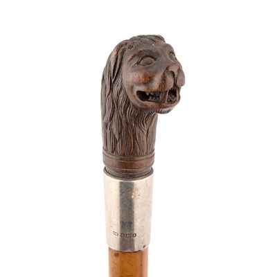 Lot 818 - A SILVER-COLLARED MALACCA CANE WITH A CARVED HANDLE