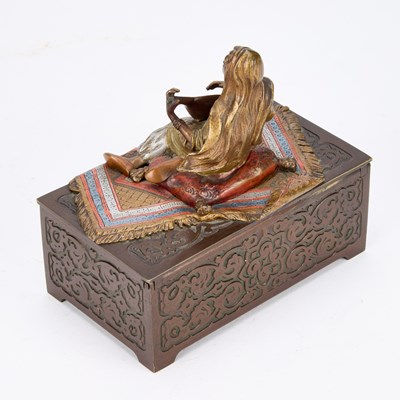 Lot AN AUSTRIAN BRONZE CIGARETTE BOX MOUNTED WITH A COLD PAINTED BRONZE FIGURE